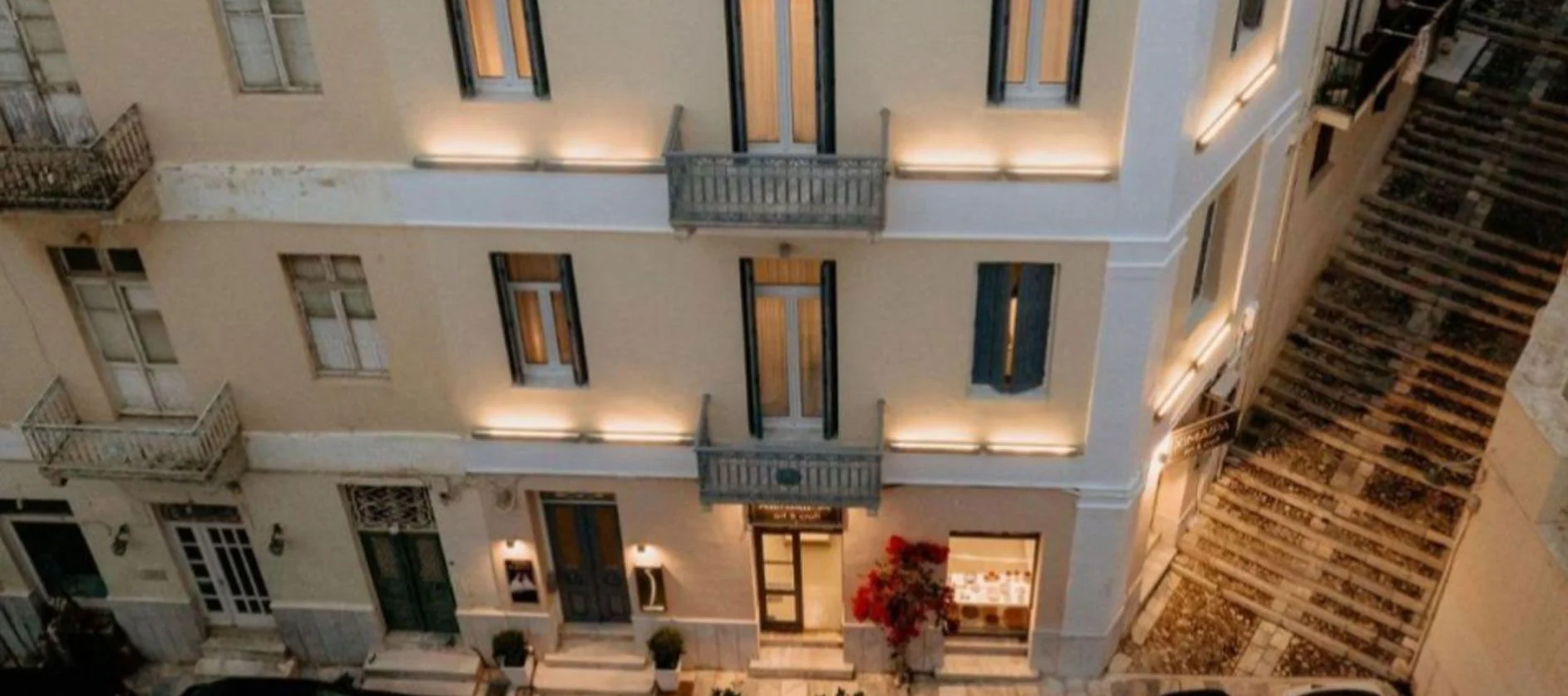The neoclassical facade of 5 Hermoupolis lit in the evening